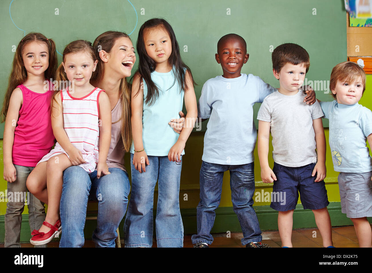 Glücklich Kindergärtnerin mit ihrer Gruppe von Kindern in einem kindergarten Stockfoto