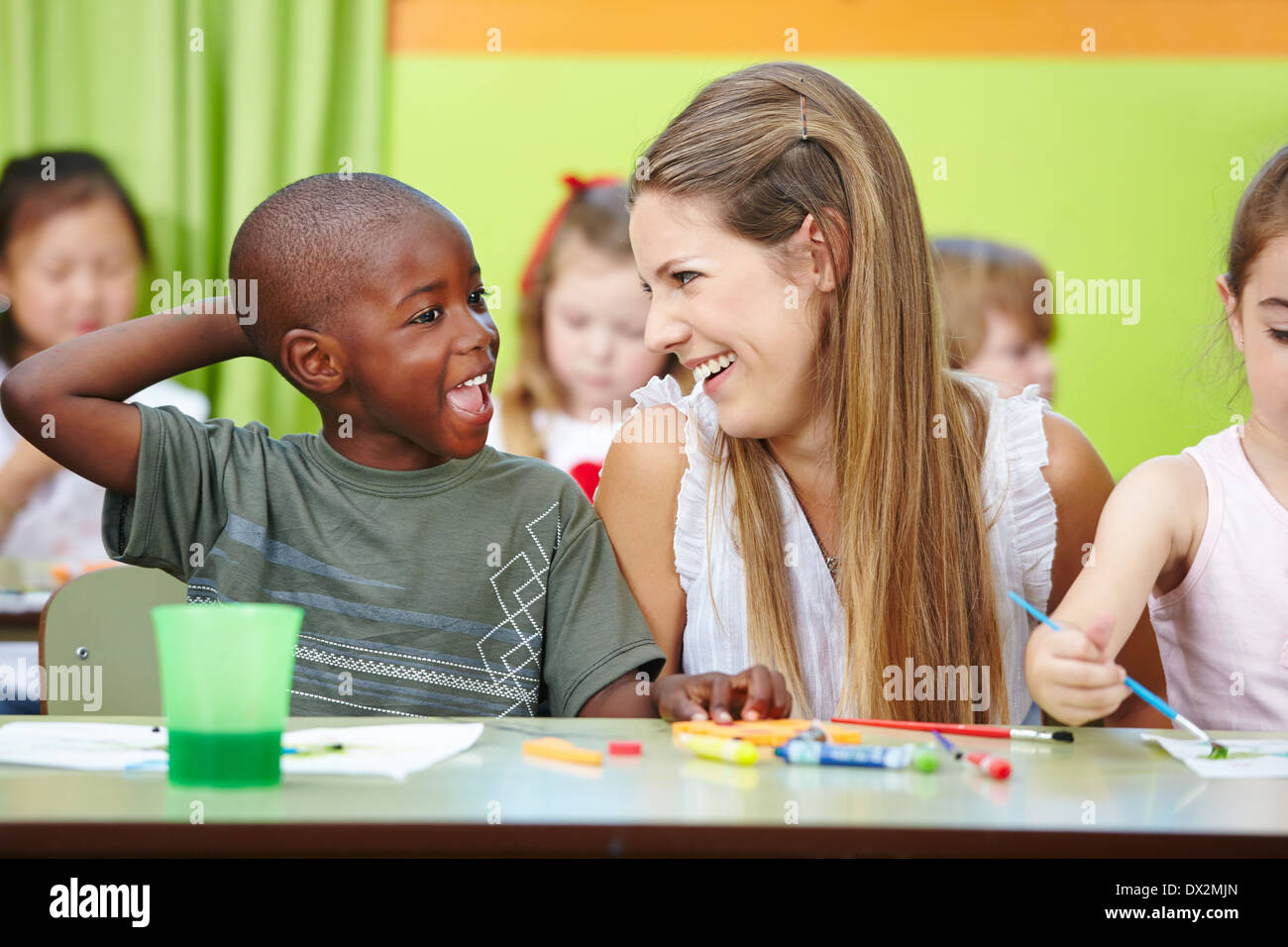 Kindergärtnerin und Kinder gemeinsam Spaß zu haben, in eine Kindergartengruppe Stockfoto