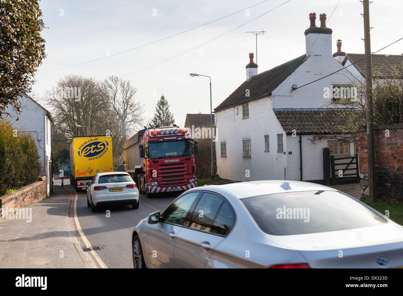 Starker Verkehr vorbei an einem Haus auf einer belebten Straße in der kleinen ländlichen Dorf Rempstone, Nottinghamshire, England, Großbritannien Stockfoto