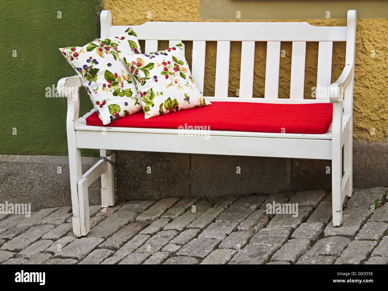 romantische Sitzbank mit Kissen im freien Stockfoto