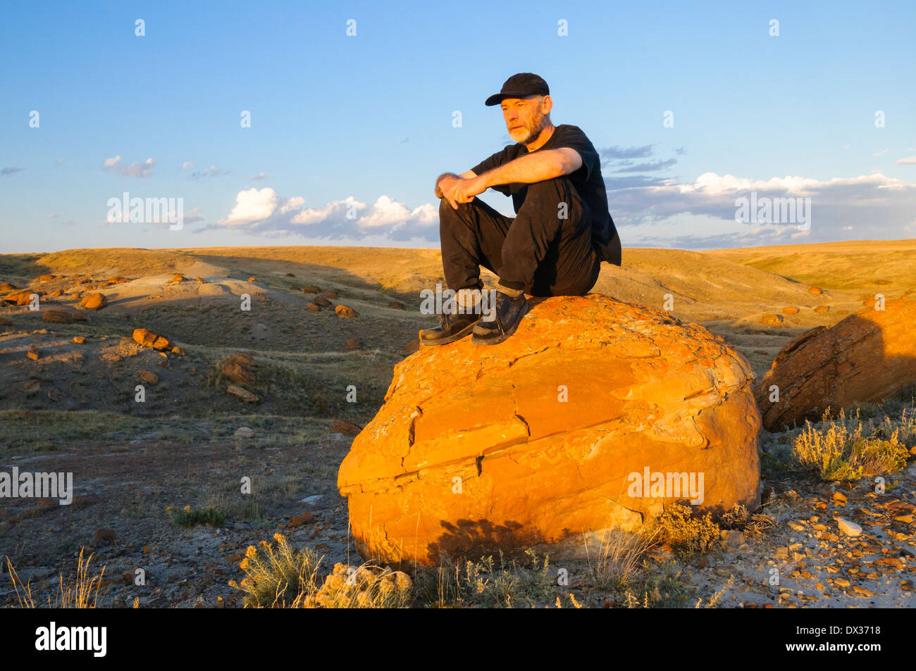 Mann auf großen Sandstein Konkretionen, Red Rock Coulee Naturraum, Alberta, Kanada Stockfoto