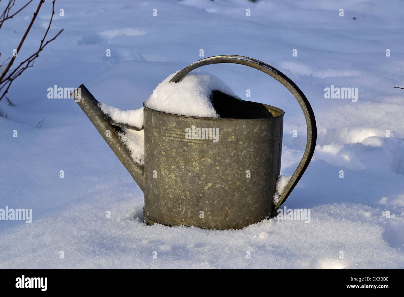 Gießkanne Zink im verschneiten Garten. (Potager de Suzanne in Mayenne, Pays De La Loire, Frankreich). Stockfoto