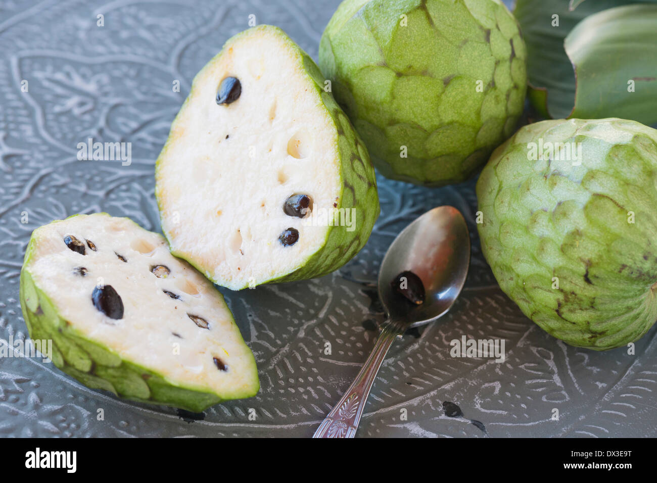 Pudding-Obst auf Metalltablett, ganze und Schnitt, mit einem Teelöffel Stockfoto