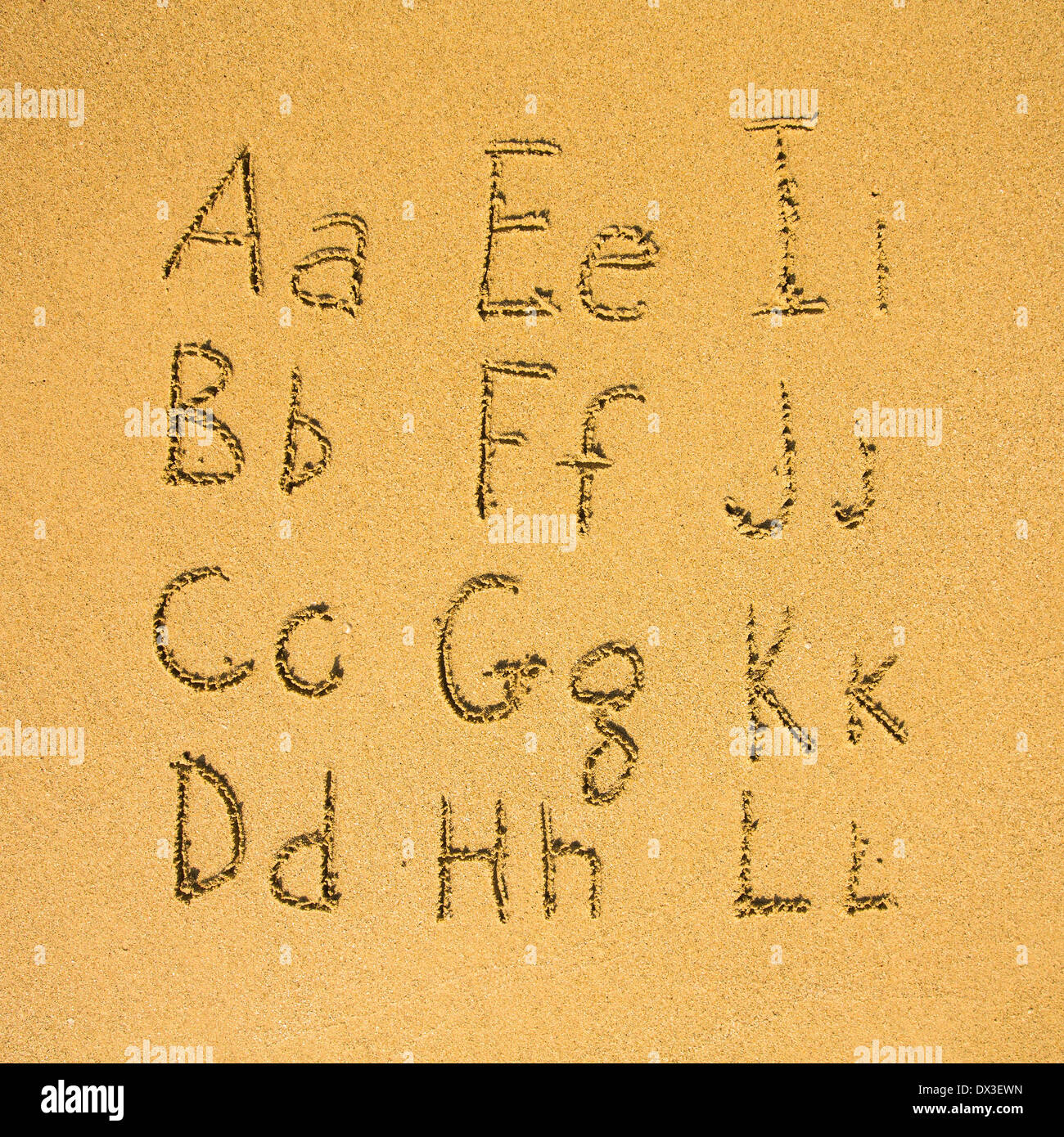Alphabet (der erste Teil von zwei) geschrieben am Sandstrand. Stockfoto