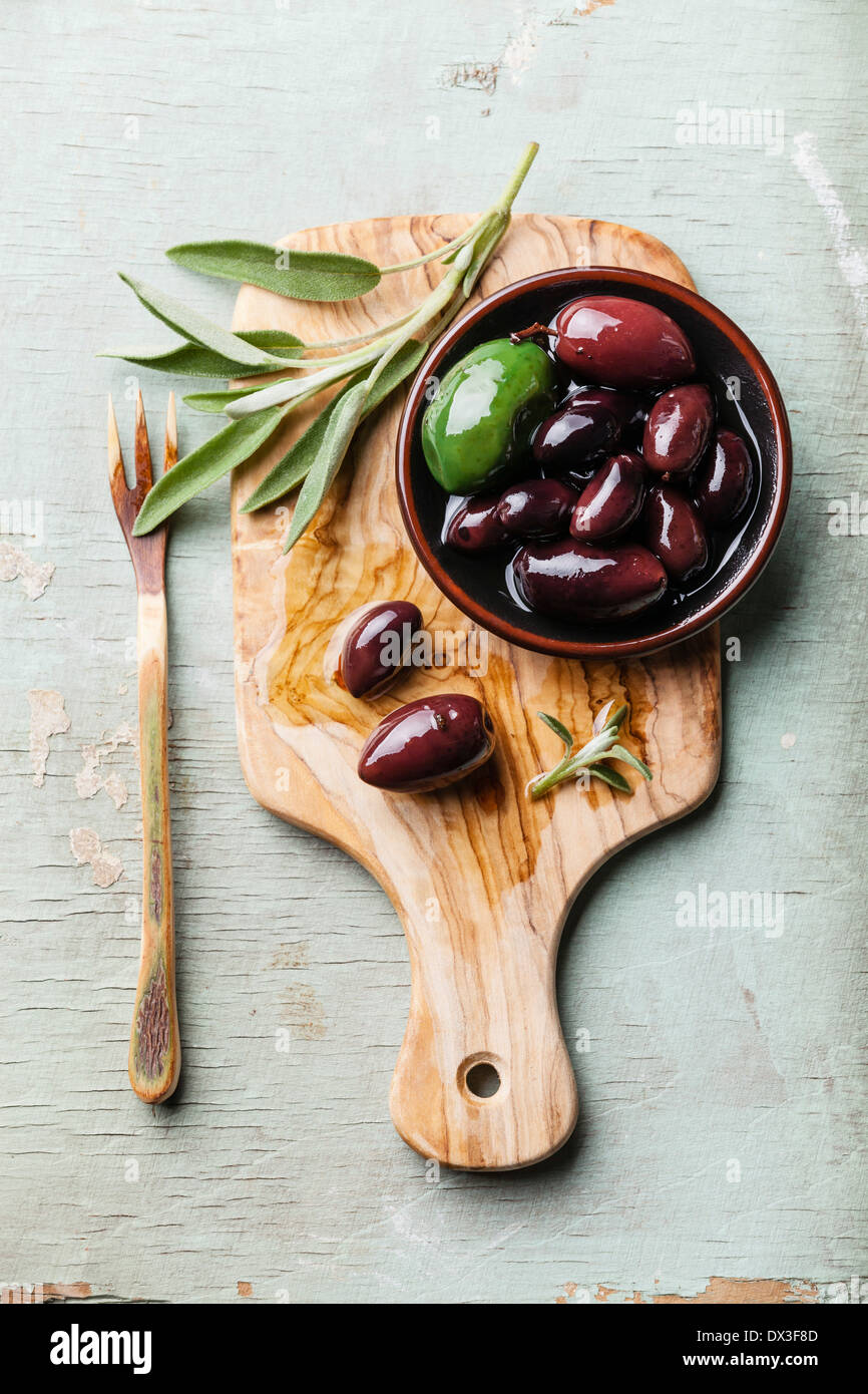 Oliven mit Salbeiblättern auf hölzernen Hintergrund Stockfoto
