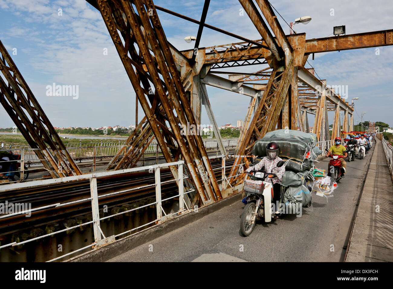 Motorräder überqueren die Long Bien-Brücke. Die Brücke überspannt den Red River ist 1682 m lang und eröffnete im Jahr 1903. Hanoi, Vietnam, Stockfoto
