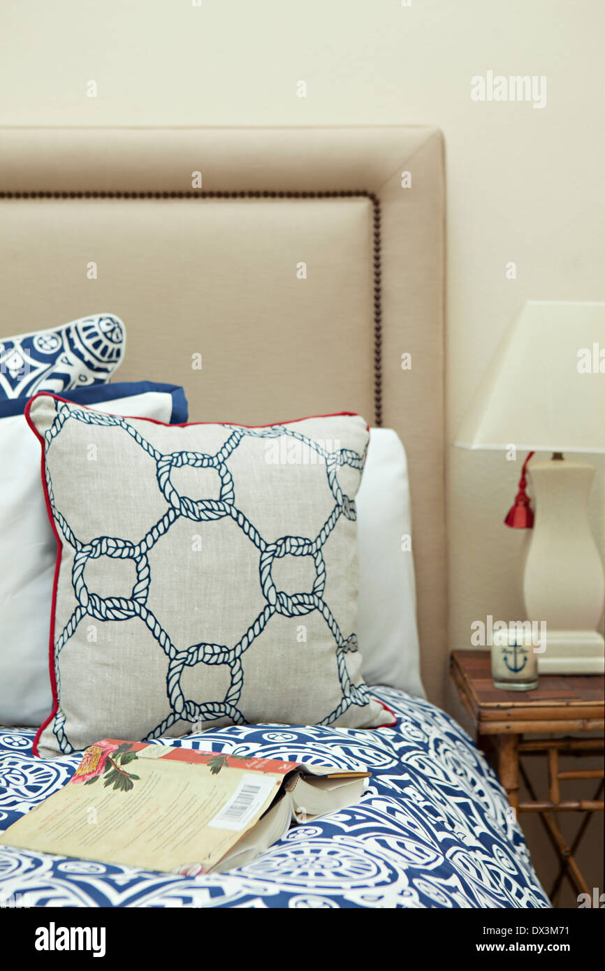 Buchen Sie auf blauen und weißen nautischen Bett im Schlafzimmer Stockfoto