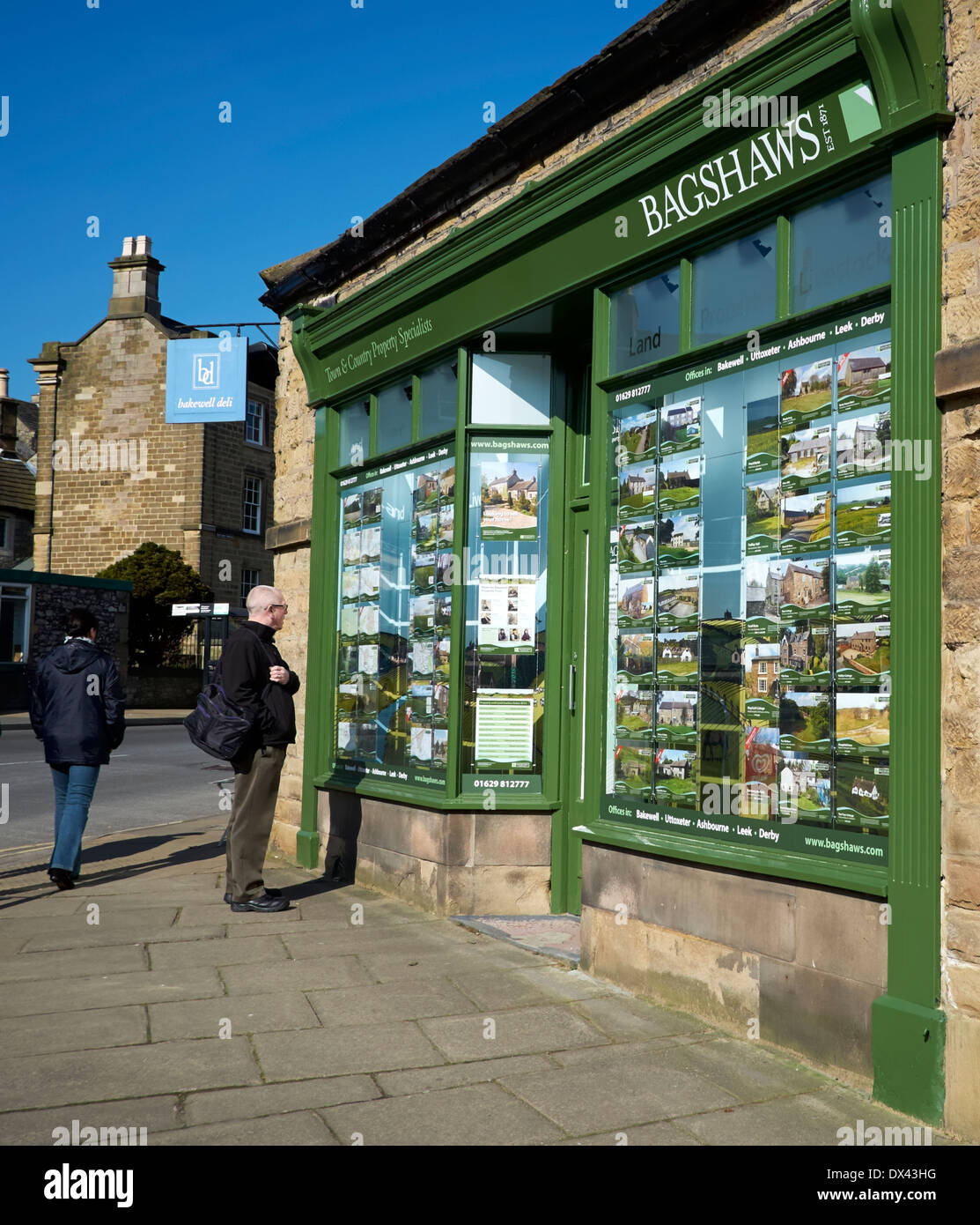 Ein einziger Mann, Blick auf ein Immobilienmakler Fenster Bakewell Derbyshire England uk Stockfoto