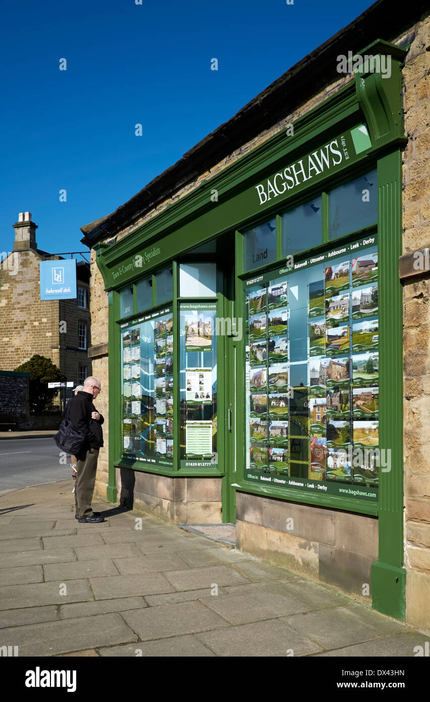 Ein einziger Mann, Blick auf ein Immobilienmakler Fenster Bakewell Derbyshire England uk Stockfoto