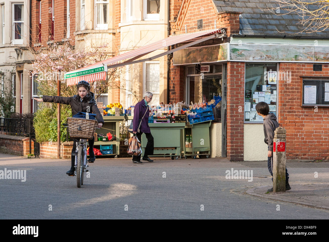 Fußgänger und Radfahrer außerhalb traditioneller Tante-Emma-Laden im Dorf Newnham, Cambridge England Stockfoto