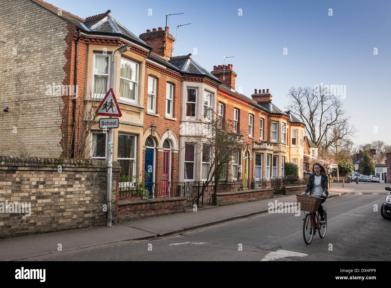 Junges Mädchen vorbei Radfahren Reihenhaus wohnen in Newnham Dorf, Cambridge England Stockfoto