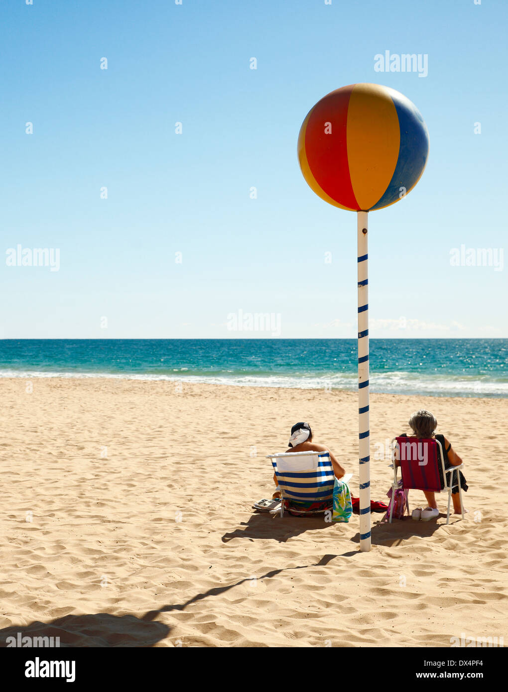 Älteres paar Wintersonne, Benidorm Strand, Spanien zu genießen. Stockfoto