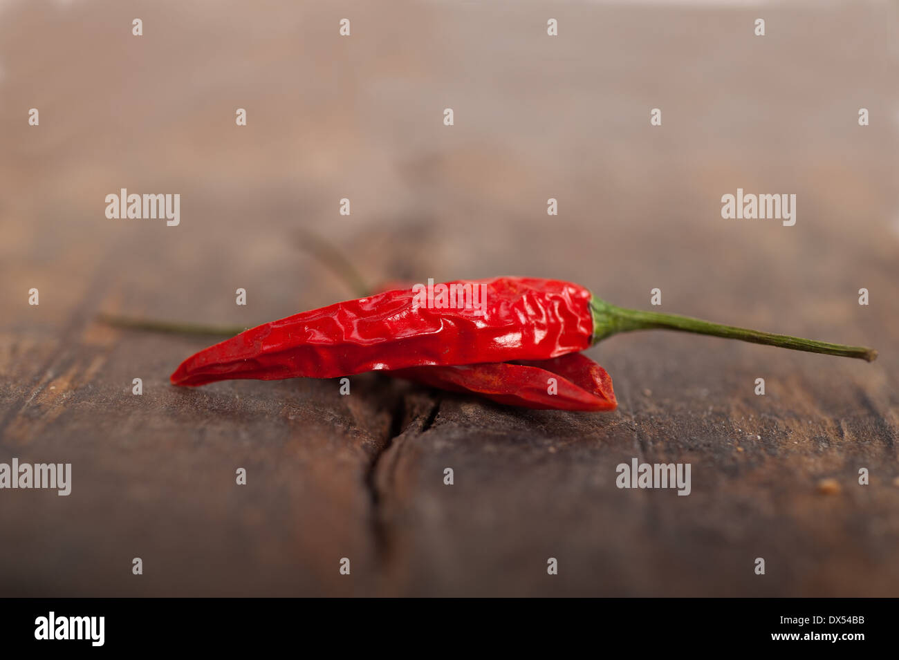 trockene rote Chilischoten über alten Holztisch Stockfoto