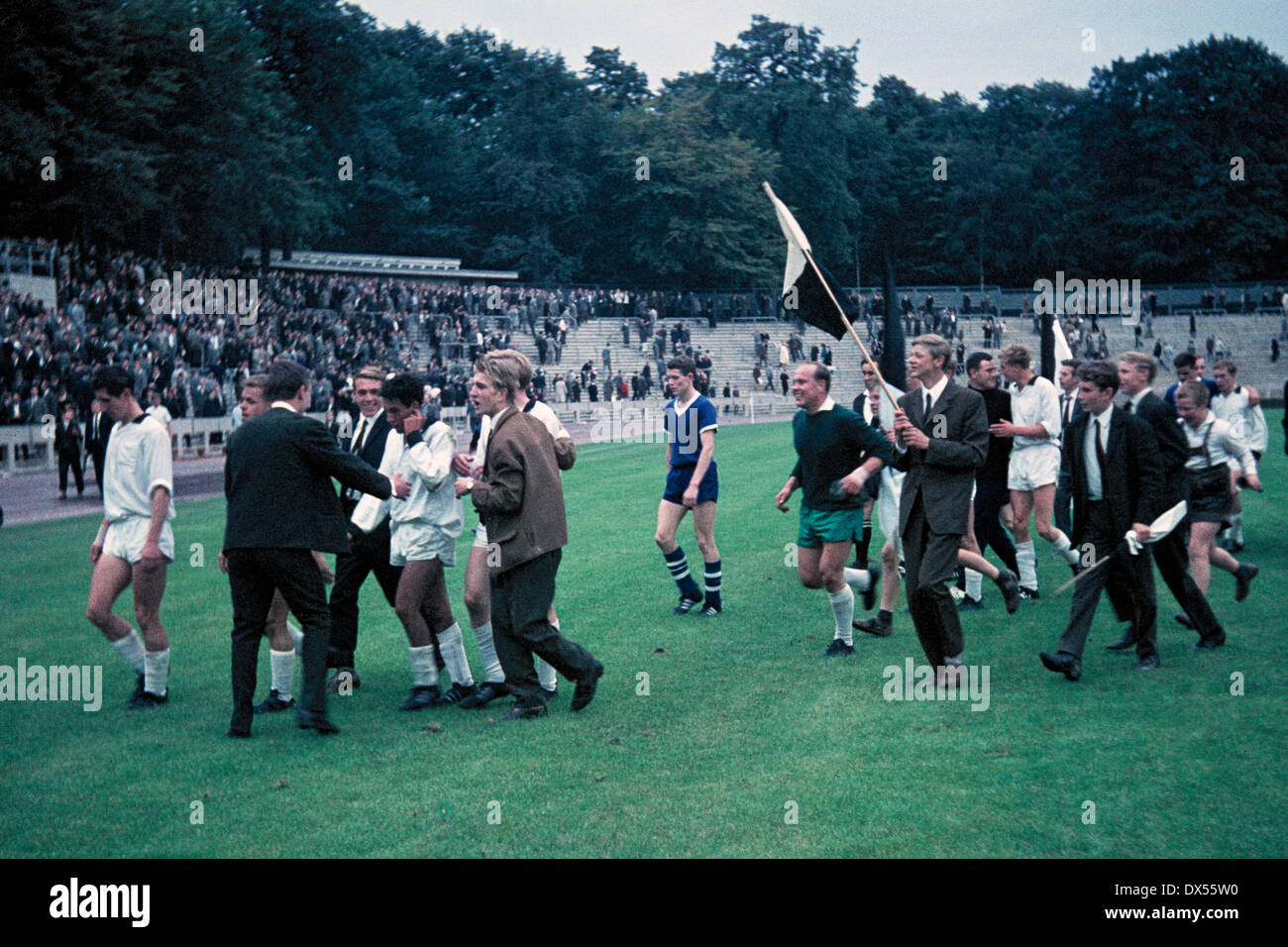 Fußball, Regionalliga West 1964/1965, Jahn-Stadion, TSV Marl-Hüls gegen Borussia Moenchengladbach 0:1, verlassen, junge Gladbacher Fußball-Fans laufen auf dem Feld feiert Werner Waddey (MG) den Siegtreffer bekam, v.l.n.r.: Heinz Lowin (MG), Albert Jansen Stockfoto