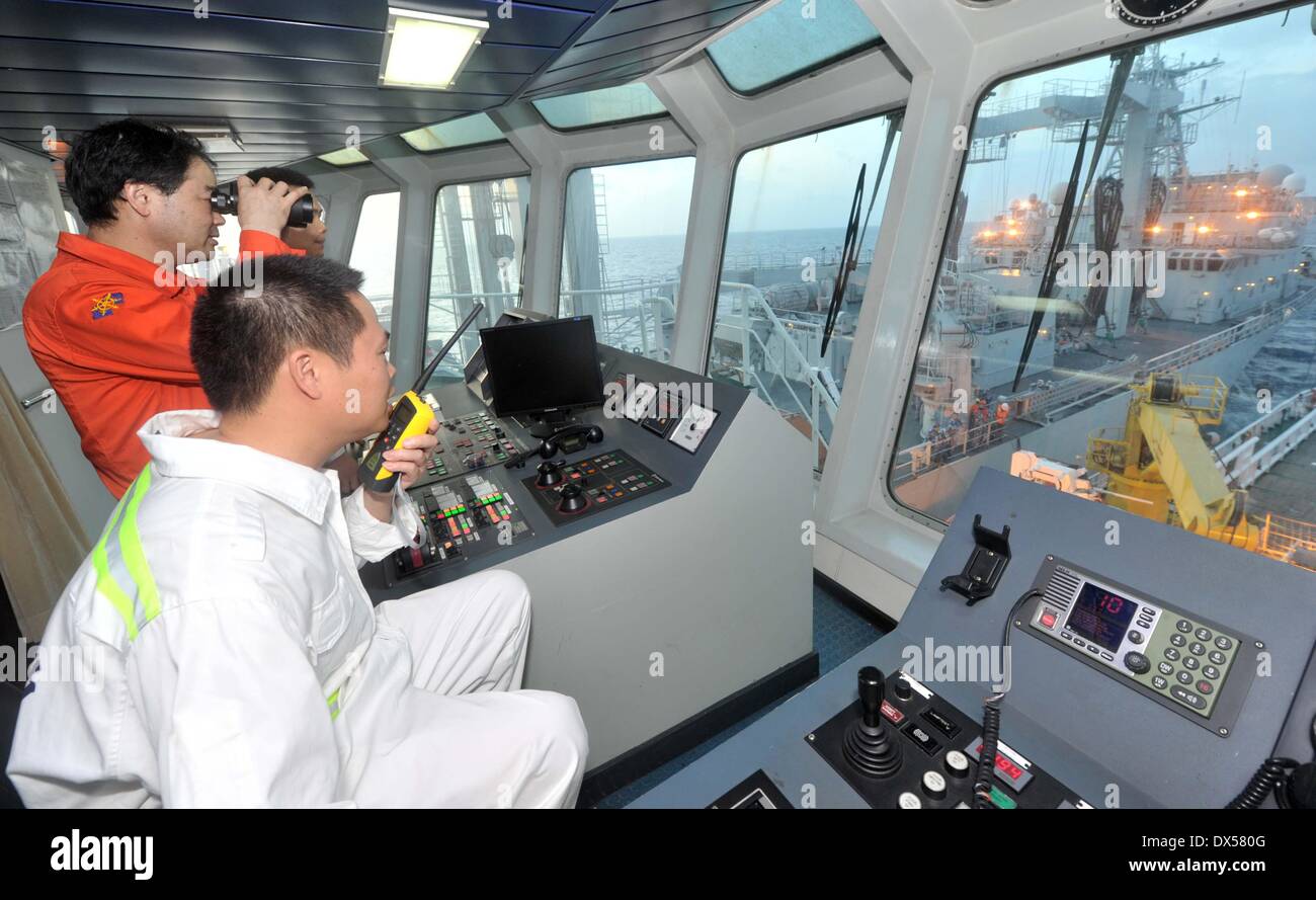 Golf von Thailand, 18. März 2014. Kapitän der chinesischen Rettung Schiff "Nanhaijiu 101" Yu Zhige und stellvertretender Kommandant Zhang Jianxin lenken, das Schiff zu nähern Qiandaohu umfassende Versorgungsschiff, wie beide von Ihnen fahren Sie in Richtung Singapur zu beteiligen, die Suche nach vermissten Malaysia Airlines Flug MH370, 18. März 2014. 08:00 am Dienstag bestellt Chinas Ministerium für Verkehr alle chinesischen Schiffe im Golf von Thailand, für die Suche in den Gewässern Südosten der Bucht von Bengalen und in der Nähe der Sunda-Straße verlassen. Bildnachweis: Xinhua/Alamy Live-Nachrichten Stockfoto