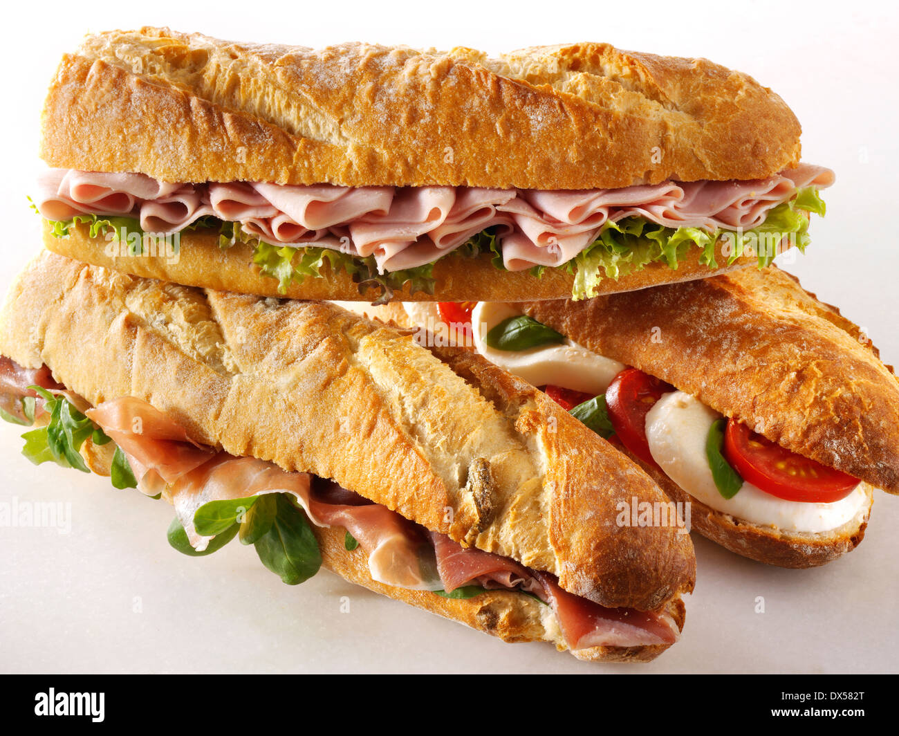 Baguette Brot gefüllt mit Mozerella & Tomaten, Schinken & Salat, Prcutto Schinken & Rakete. Stockfoto