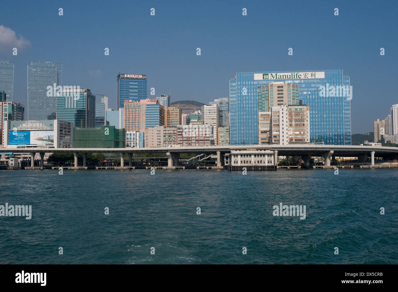 Der kleine Uferpromenade Kwun Tong Fährhafen ist Towerd durch die vielen Hochhäuser in der Gegend. Stockfoto