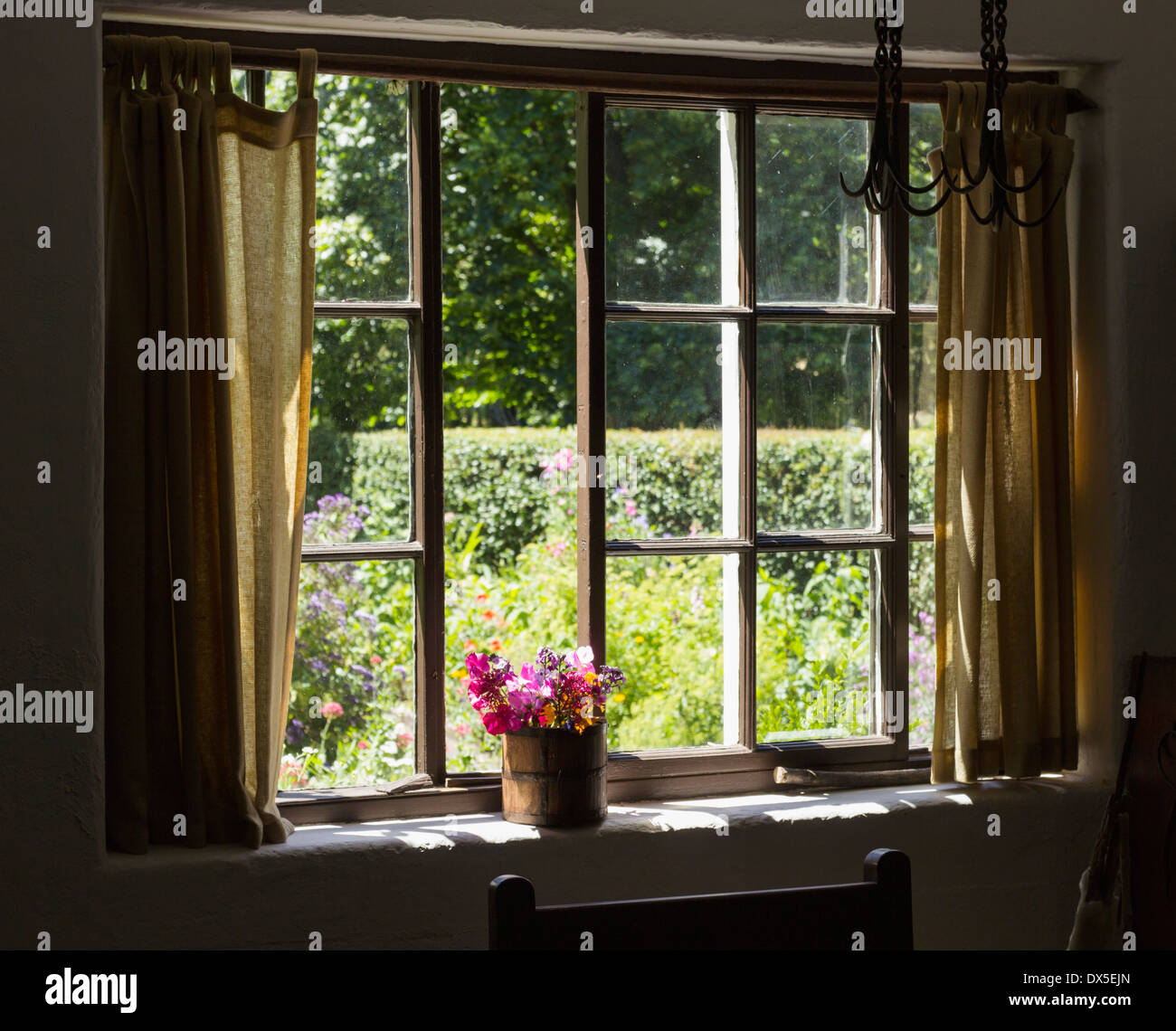 Cottage-Garten - Blick in einen hübschen Garten durch ein Fenster im Sommer Stockfoto