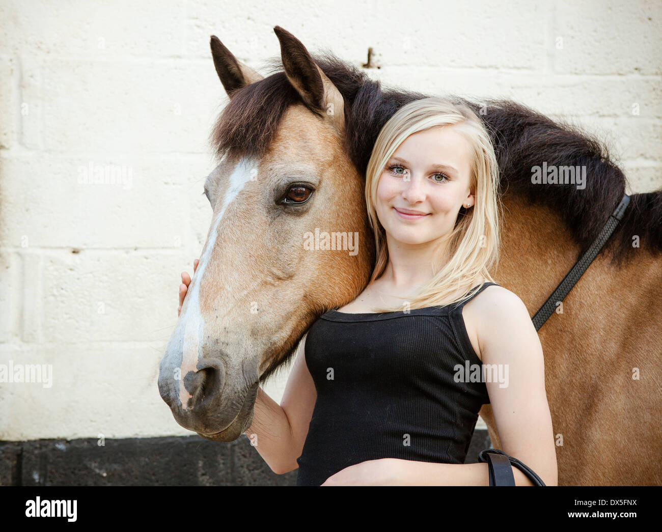 Porträt von einem jungen blonden Mädchen und ihre braunen Pferd Stockfoto