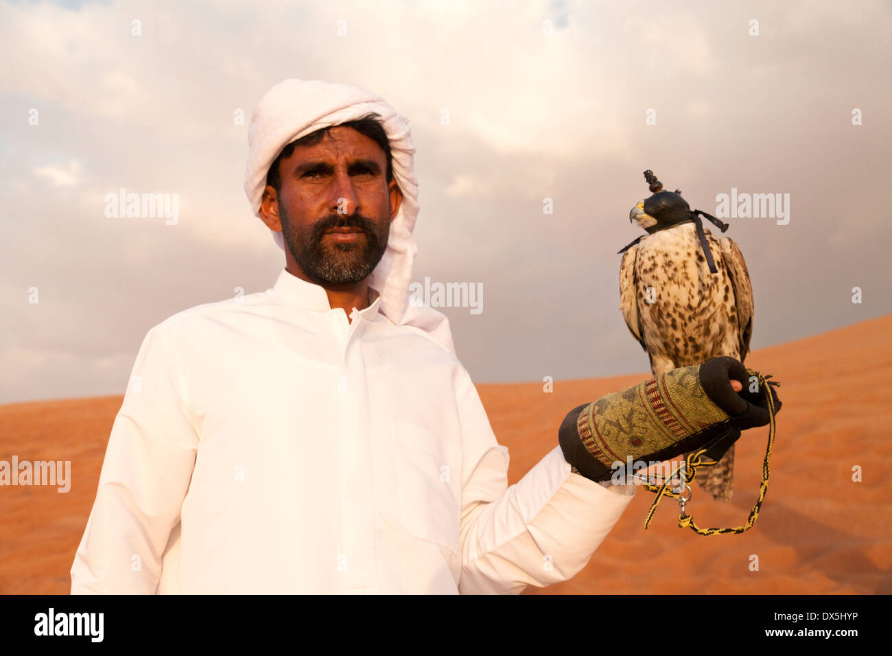 Ein Beduinen-Araber mit einem zahmen Falken posieren für die Touristen, die Arabische Wüste, Dubai, Vereinigte Arabische Emirate, Vereinigte Arabische Emirate, Naher Osten Stockfoto