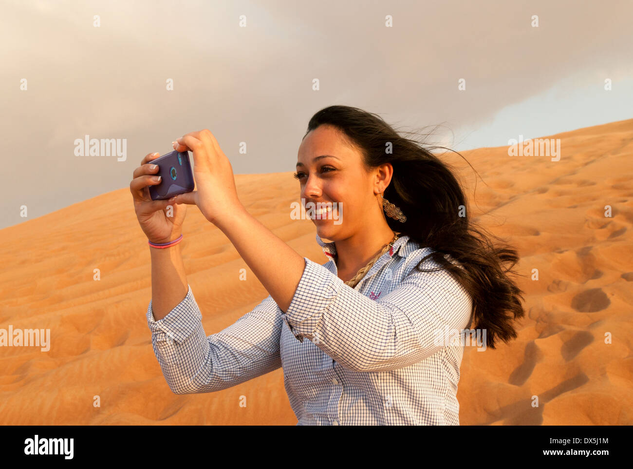 Frau fotografieren Selfie in der arabischen Wüste, im Urlaub in Dubai, Vereinigte Arabische Emirate, Vereinigte Arabische Emirate Naher Osten Stockfoto