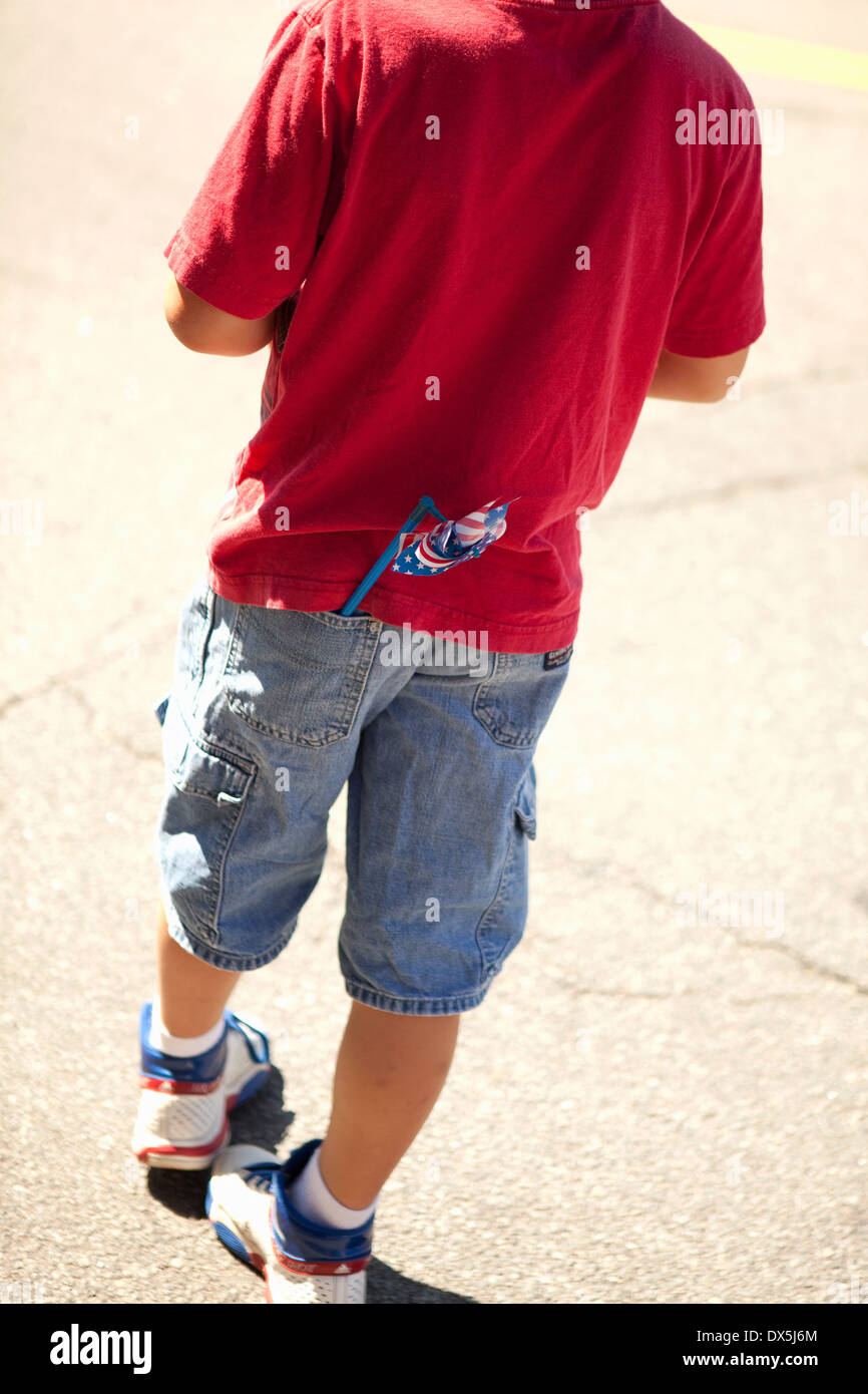 Junge mit amerikanische Flagge Windrad in der Gesäßtasche der Hose, sonnige, erhöhte Ansicht, tilt Stockfoto
