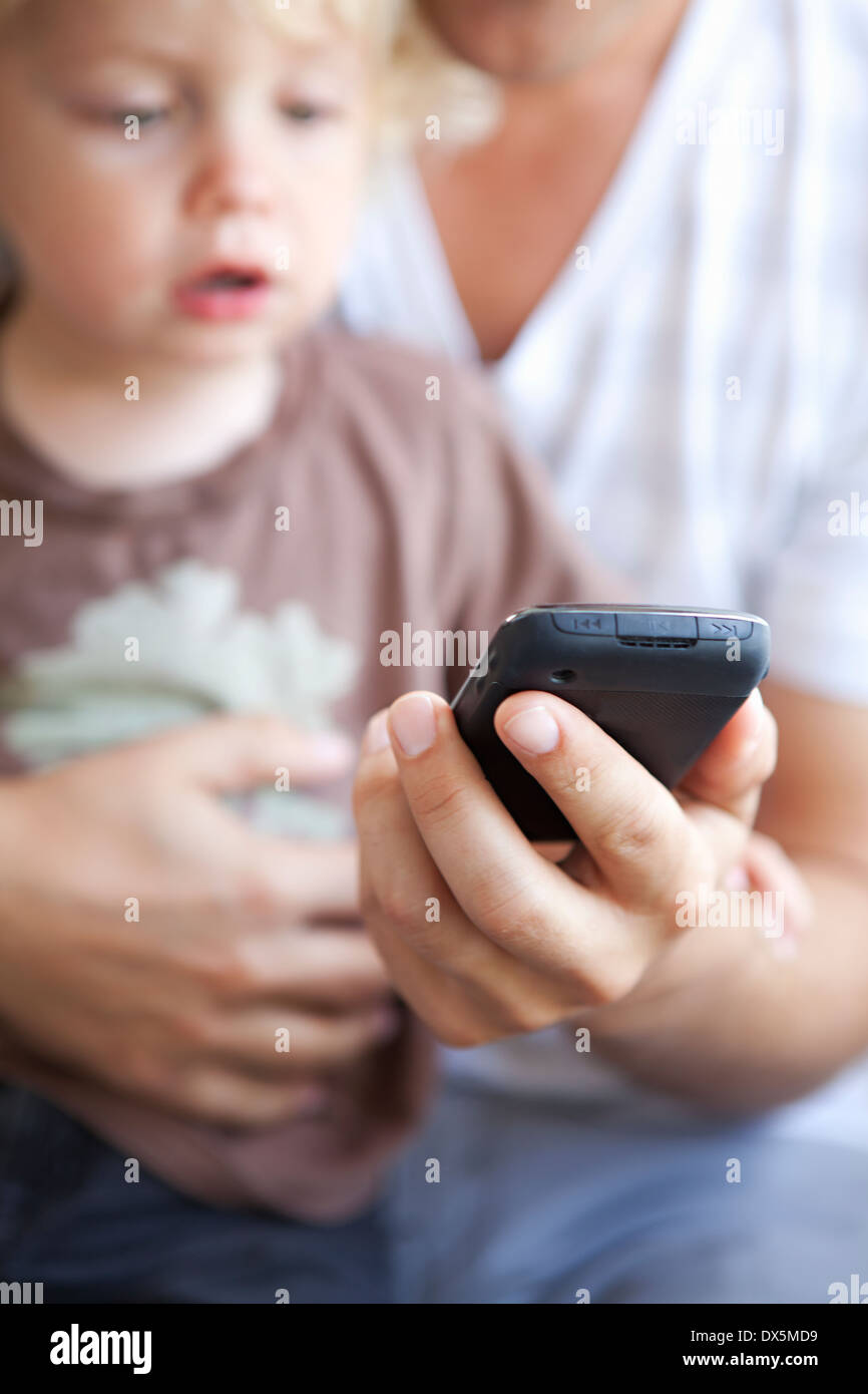 Vater zeigt Smartphone neugierig Sohn, Nahaufnahme Stockfoto