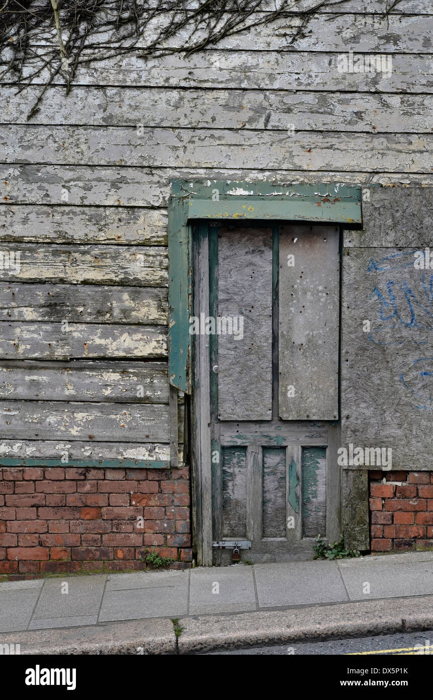 Verlassene städtische Wohnung (Laden) mit Fenstern und alter Tür. Stockfoto