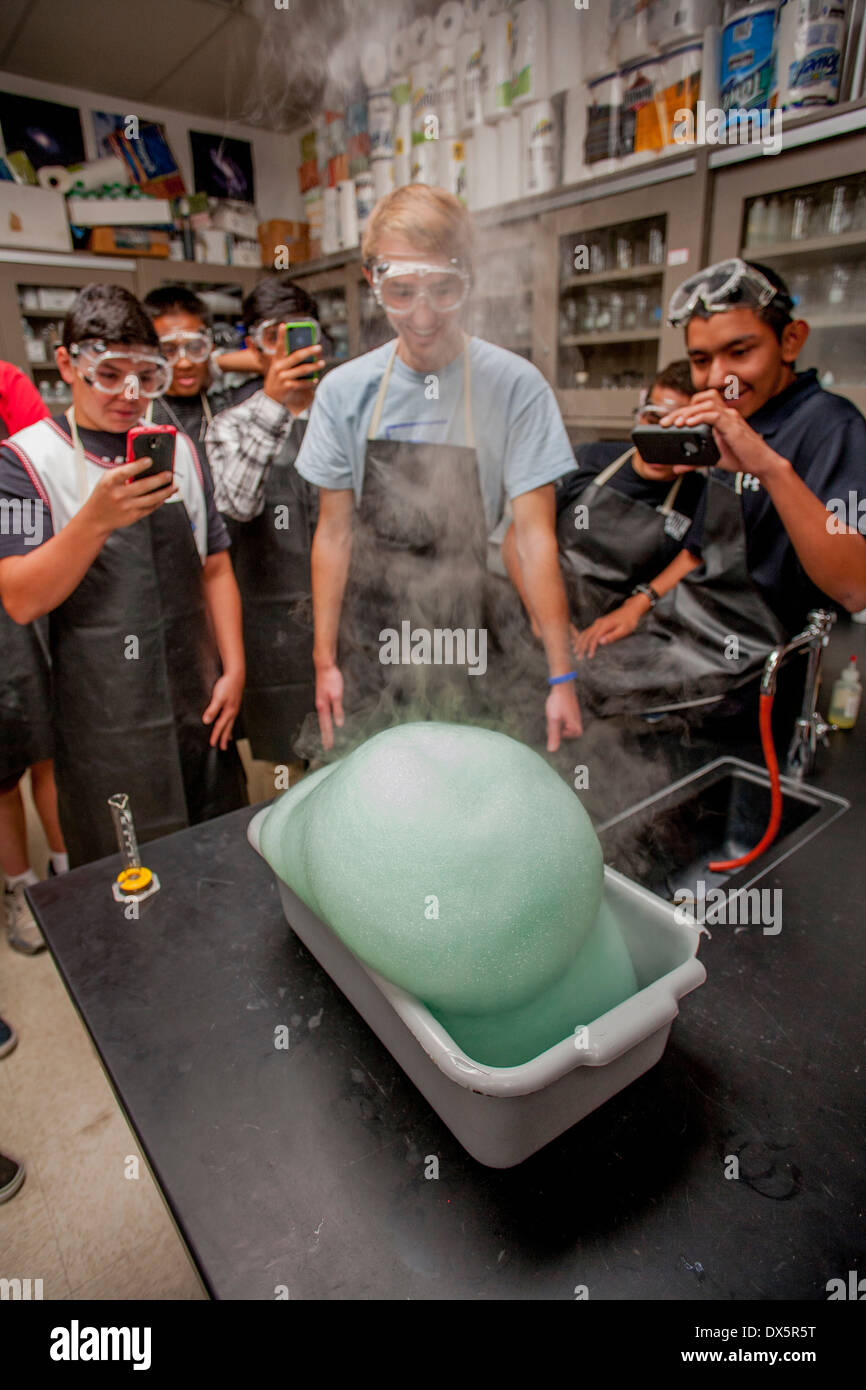 Gemischtrassig San Clemente, CA, Gymnasium Chemie Schüler zusehen, wie Wasserstoffperoxid, Seife und Natriumiodid sind gemischt, um eine expandierende Schaum Sauerstoff gefangen in daraus resultierenden Seifenblasen erzeugen. Hinweis: Handy-Kameras, Schutzbrille und Schürzen. Stockfoto