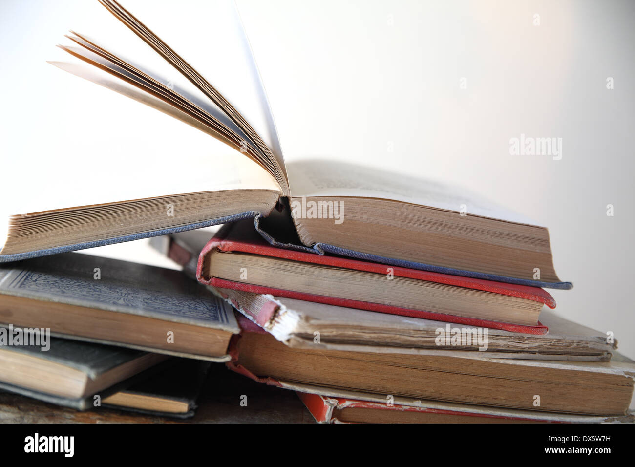 stapelt der alten Bücher neben einem Fenster Stockfoto