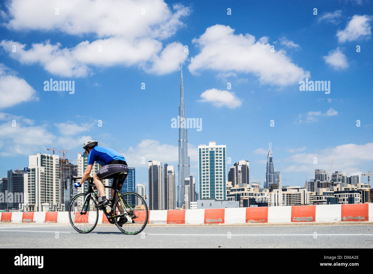Radfahrer auf Zyklus verfolgen mit Skyline von Dubai in Vereinigte Arabische Emirate Stockfoto