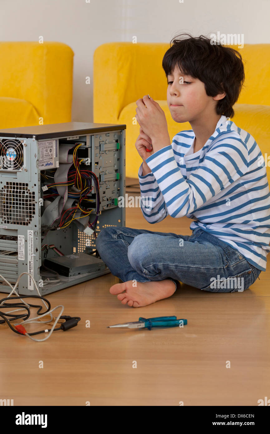Kleiner Junge das Innere eines Computers mit großer Aufmerksamkeit zu ...