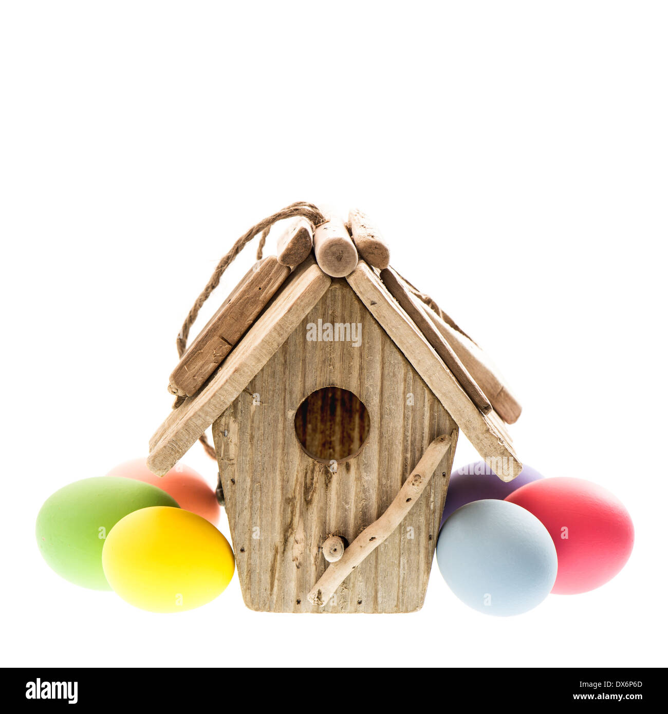Oster-Deko mit Vogelhaus und bunten Eiern auf weißem Hintergrund Stockfoto