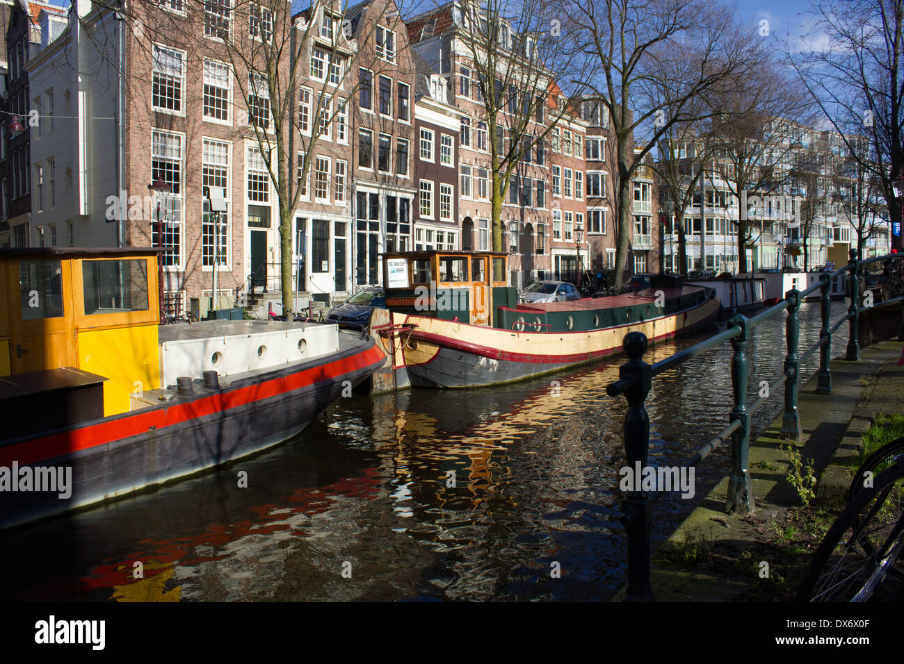 Kanal Lastkähne auf holländischen Kanal mit historischen Lagerhallen in Hintergrund Amsterdam Niederlande Stockfoto