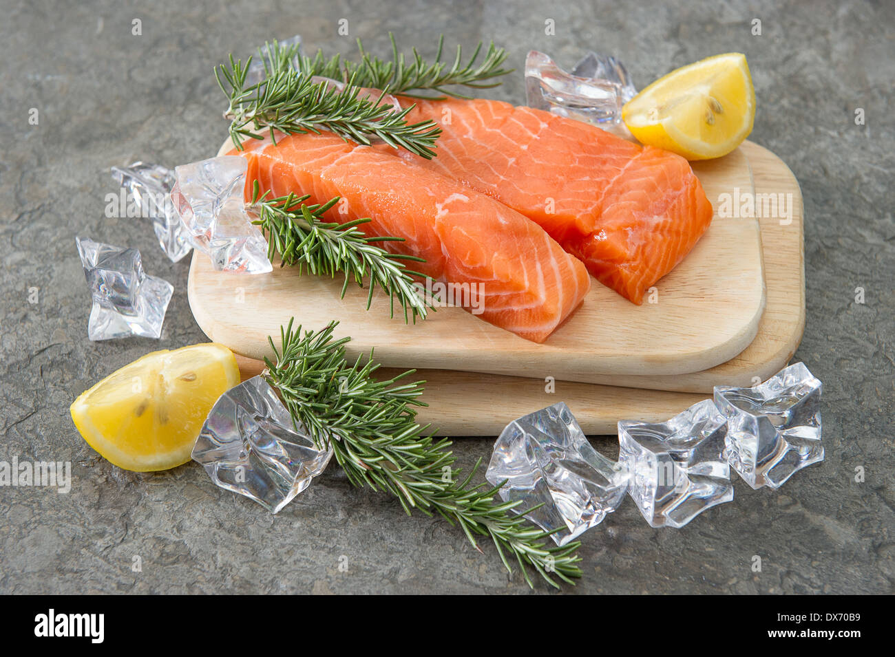 rohem Lachsfilet mit frischem Rosmarin Kräuter, Zitrone und Eis. gesunde Ernährung. Fisch und Meeresfrüchte. Fisch Stockfoto