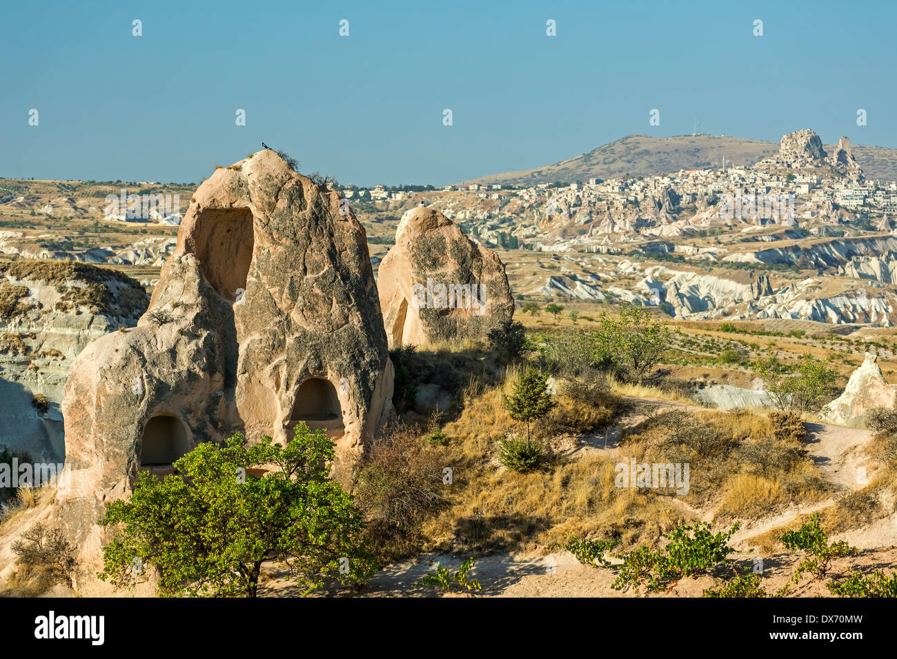 Wohnungen in Feenkamine und Uchisar (R) in der Ferne, Red Valley, Kappadokien, Türkei Stockfoto
