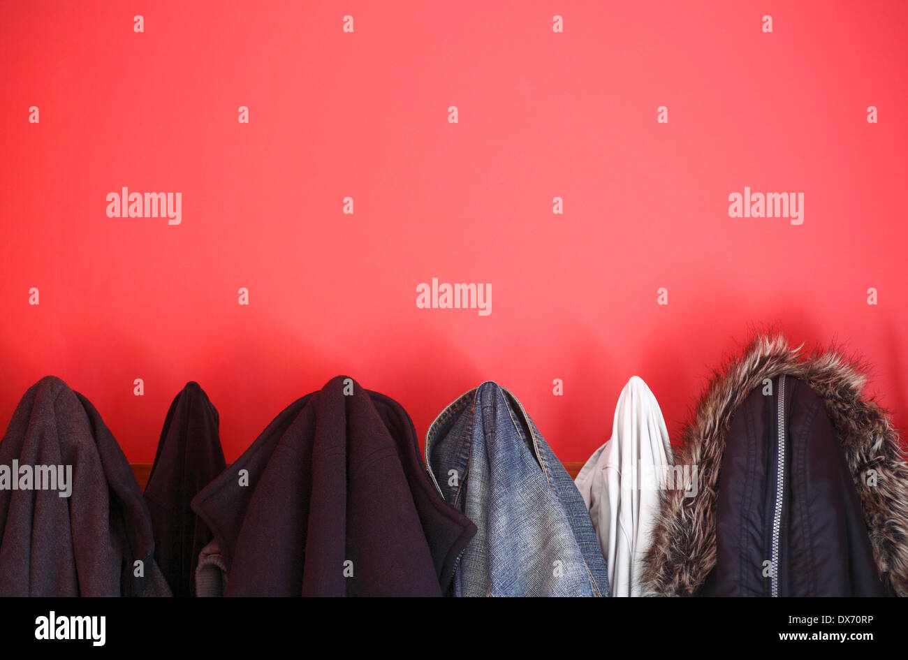Mäntel und Jacken in rot lackierte Garderobe hängen Stockfotografie - Alamy