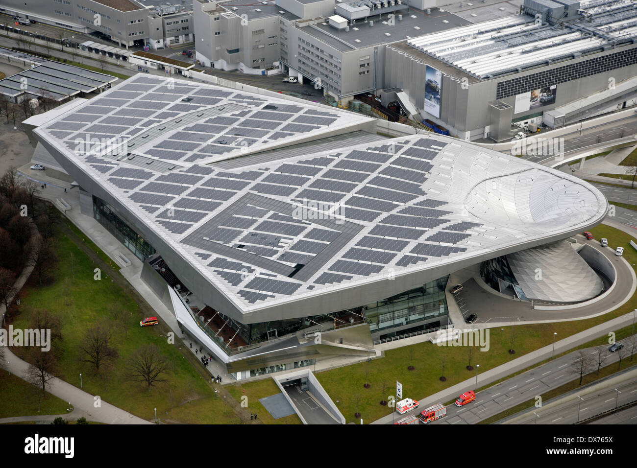 Sonnenkollektoren auf dem Dach der BMW Welt und BMW Welt, München mit dem BMW Werk hinter. Stockfoto