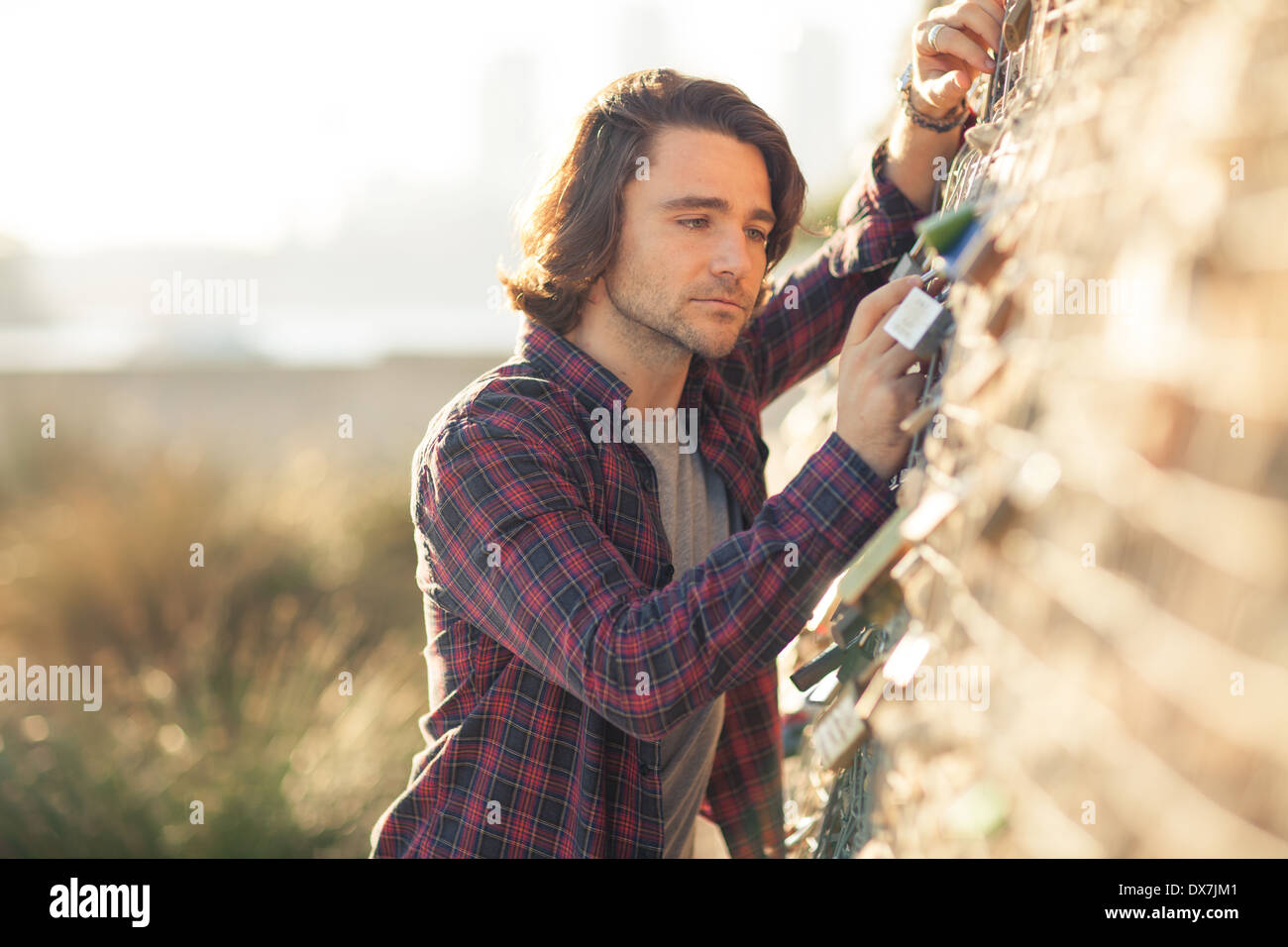 Ein junger Mann suchen nachdenklich und ernst in einer Umgebung im freien Stockfoto