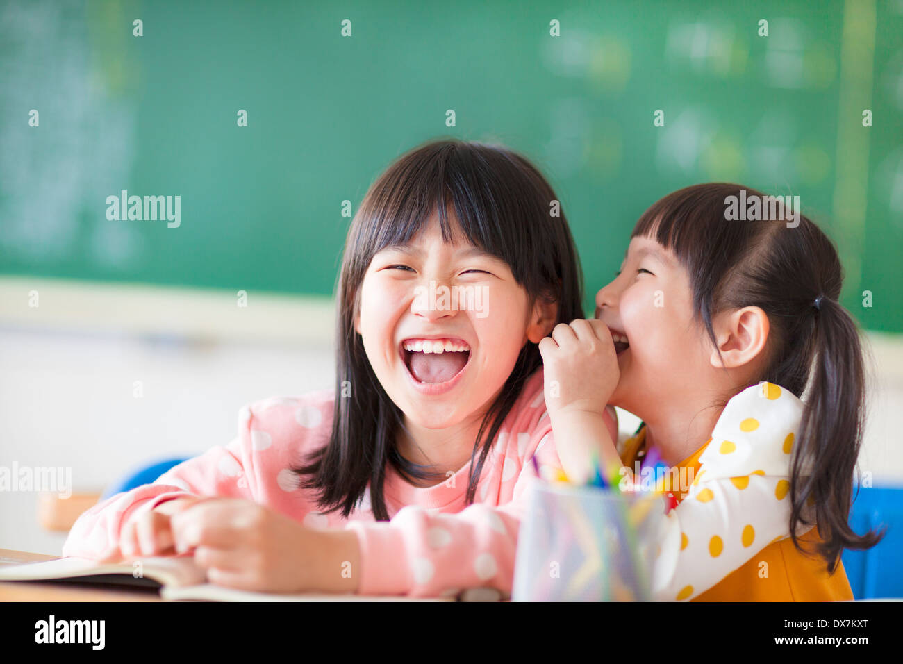 Kleine Geheimnisse in der Klasse Mädchen Lachen Stockfoto