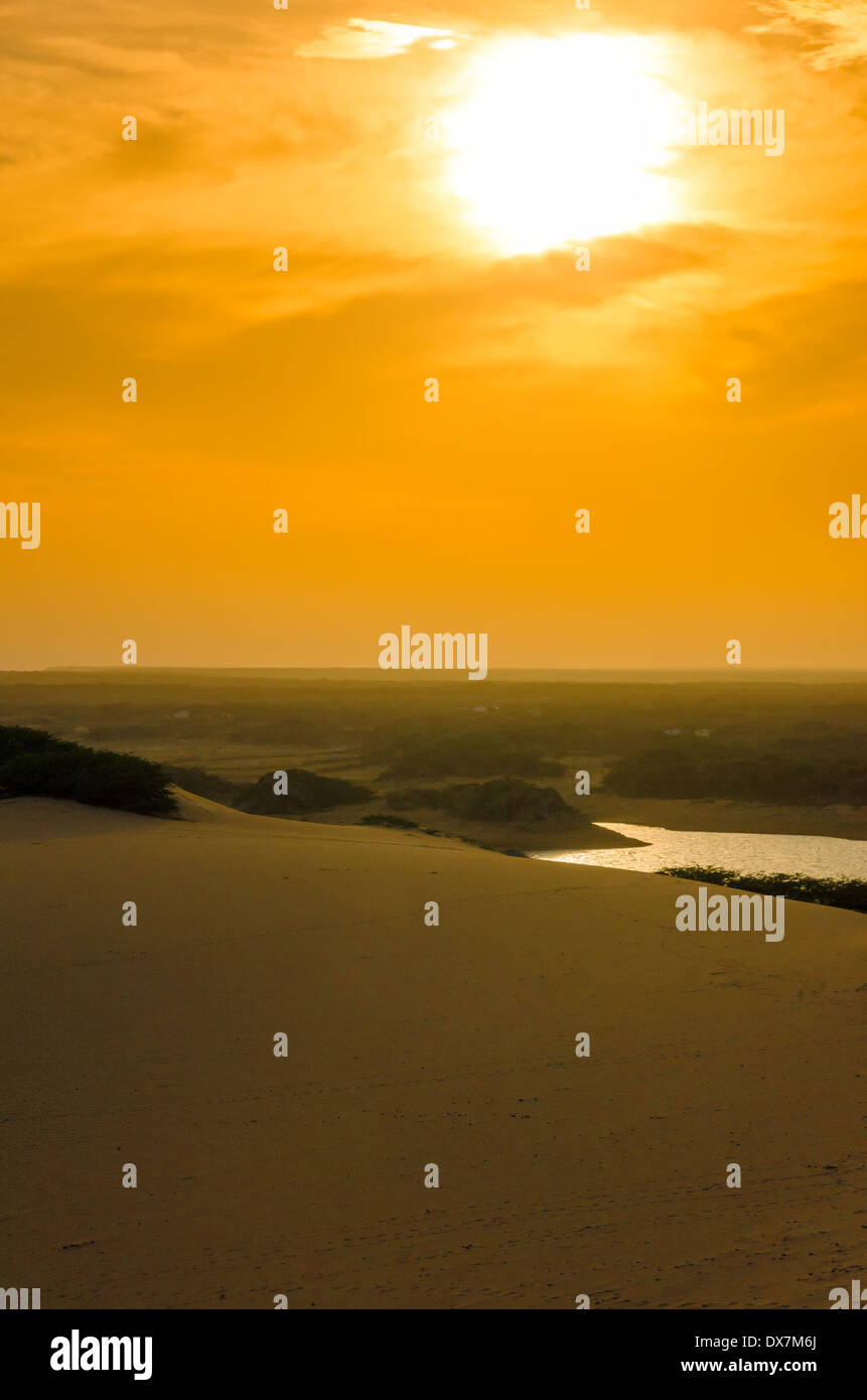 Leuchtend orange Sonnenuntergang über einer Sanddüne in La Guajira, Kolumbien Stockfoto