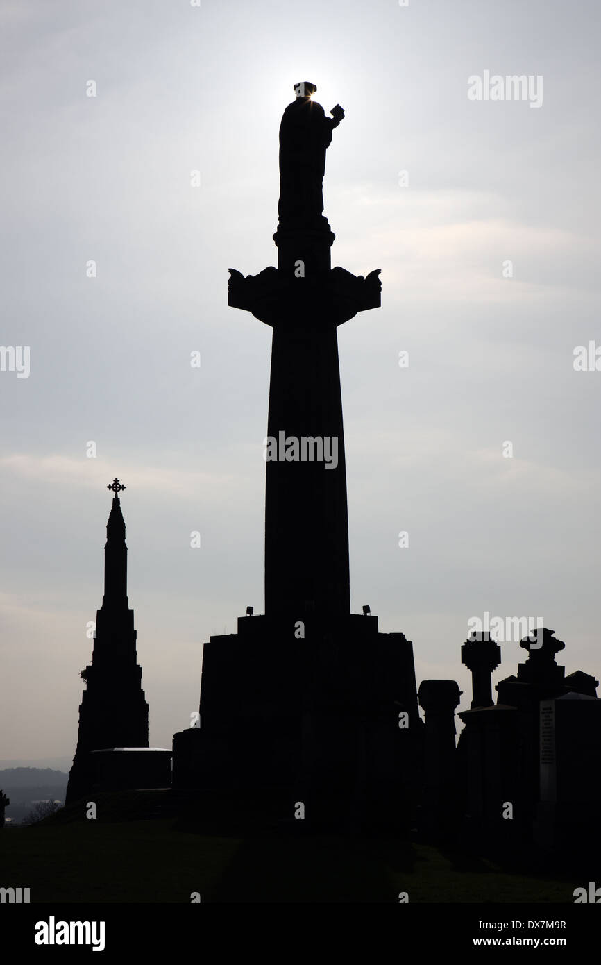 John Know Statue Silhouette überragt die anderen Grabsteine in der Nekropole in Glasgow, Schottland Stockfoto