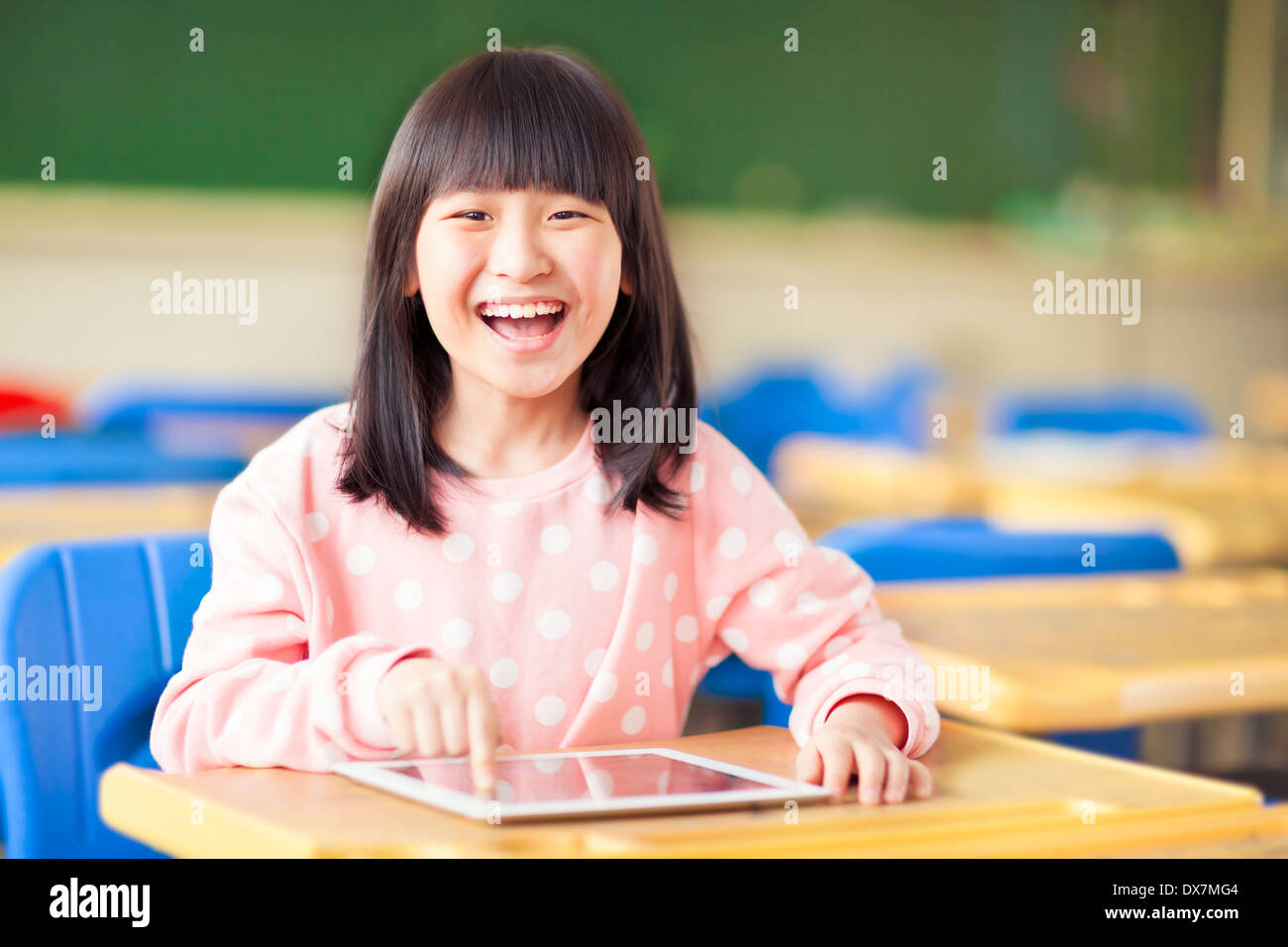 glückliche kleine Mädchen mit Tablet oder ipad Stockfoto