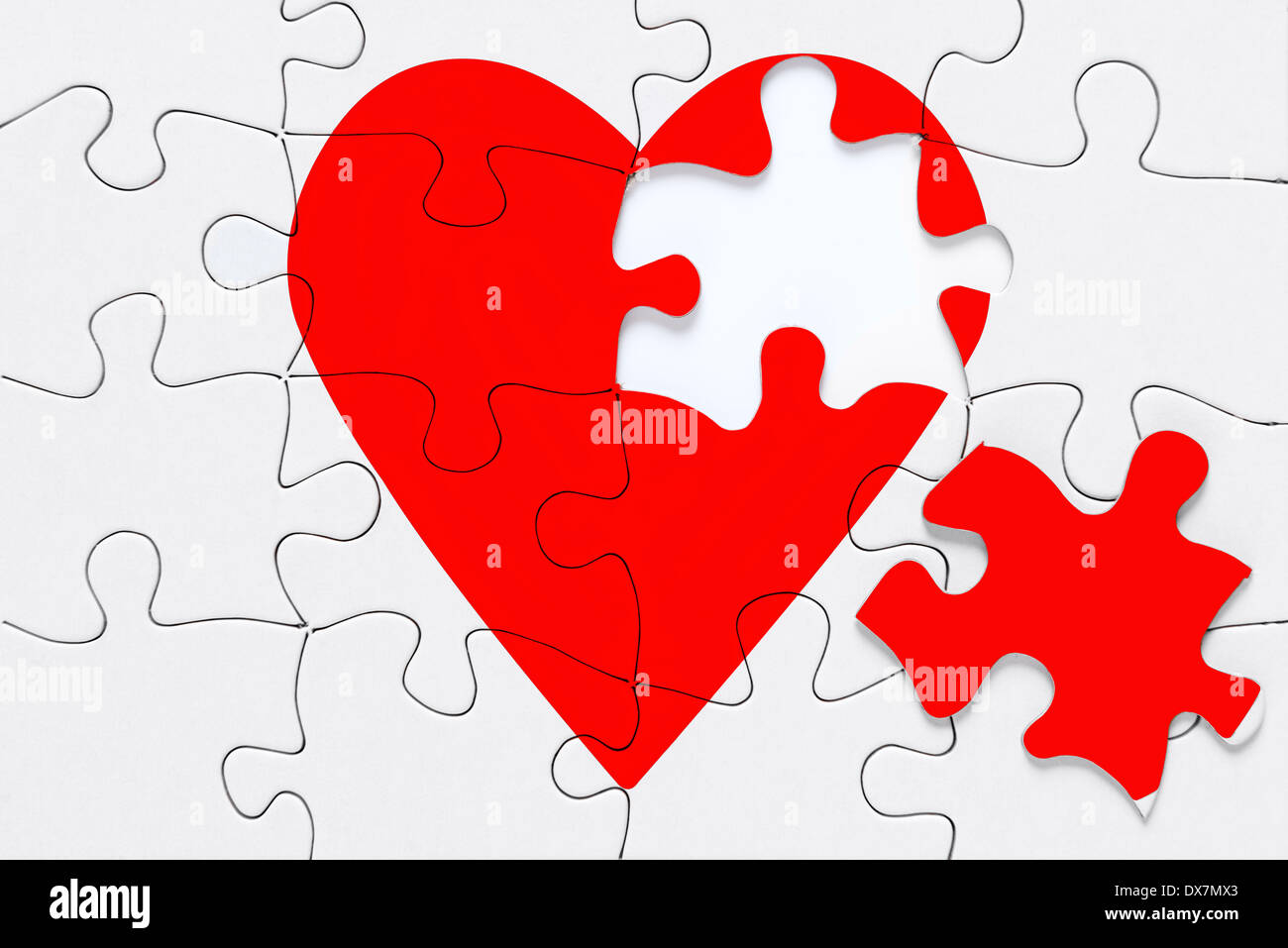 Ein rotes Herz Puzzle puzzle mit einem Stück auf der Seite, gutes Bild für ein gebrochenes Herz, Liebe, Romantik und Valentinstag Themen. Stockfoto