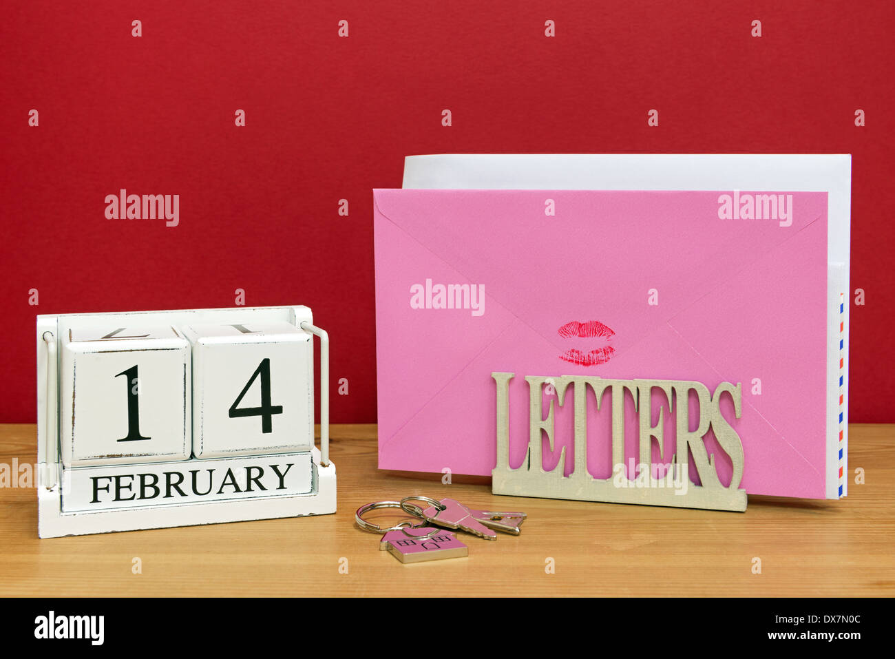 Versiegelt mit einem roten Lippenstift Kuss in einer Letterack mit einem Datum Block zeigt 14. Februar Valentinstag Karte. Stockfoto