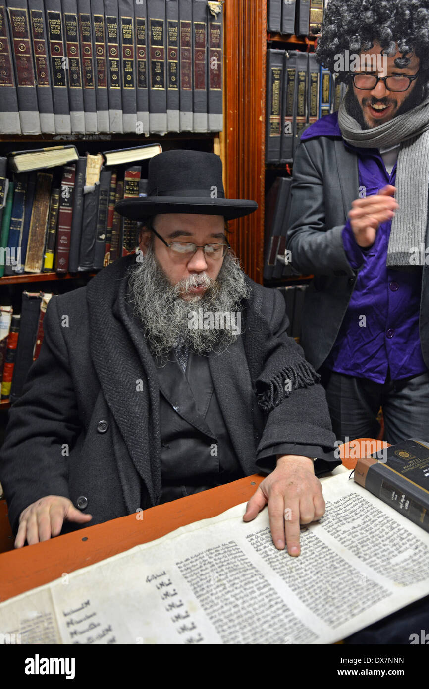 Einen religiösen jüdischen Mann lesen aus der Megillah während Purim Besude einen Mann im Kostüm. In Crown Heights, Brooklyn, New York Stockfoto