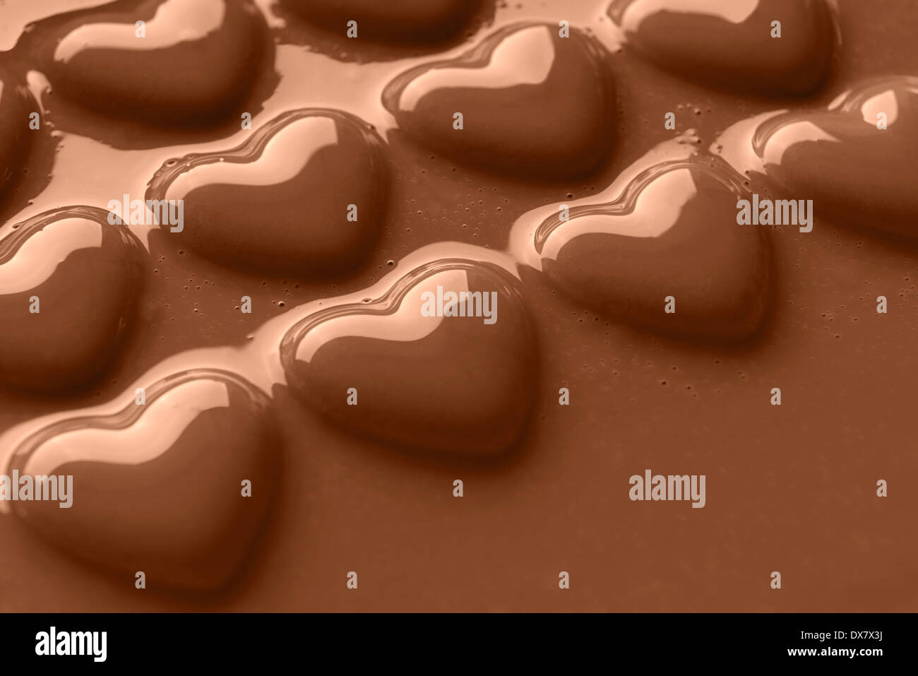Foto von Schokoladenherzen in cremiger Milchschokolade erschossen in einem Winkel mit textfreiraum für Ihre eigene Nachricht behandelt. Stockfoto