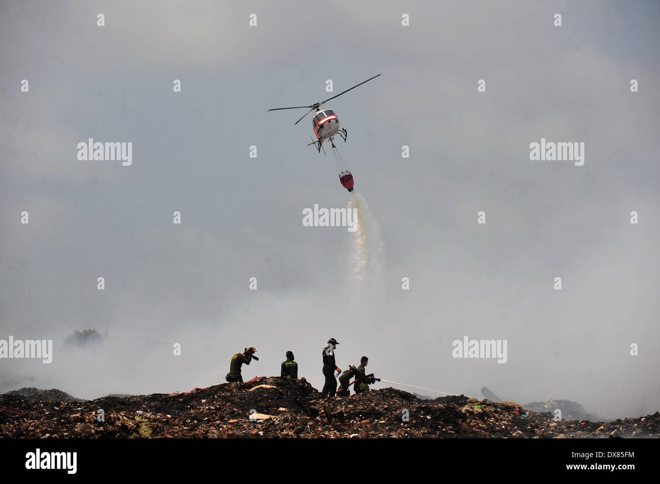 Samut Prakan, Thailand. 20. März 2014. Feuerwehr löschte ein massives Feuer auf einer Müll-Deponie in der Provinz Samut Prakan, Thailand, 20. März 2014. Ein Feuer in der Provinz Samut Prakan in Thailand am 16. März begann und giftige Gase in die Luft freigesetzt. Menschen in der Nähe der brennende Müllhalde mussten Zuflucht außerhalb des Gefahrenbereichs. Bildnachweis: Rachen Sageamsak/Xinhua/Alamy Live-Nachrichten Stockfoto