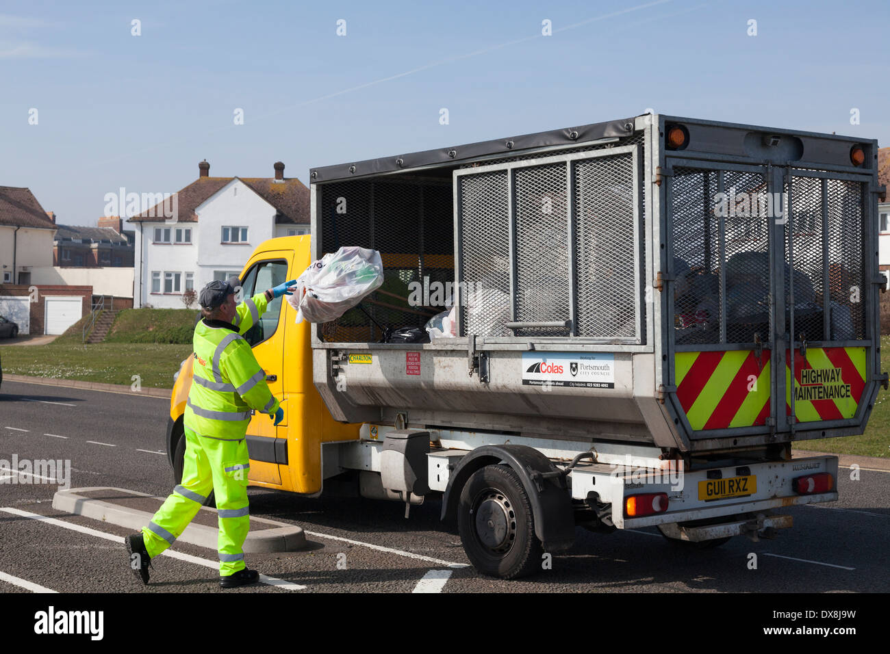 Des Rates Arbeiter in Warnkleidung werfen Müll in kleine Sammlung Müllwagen. Stockfoto