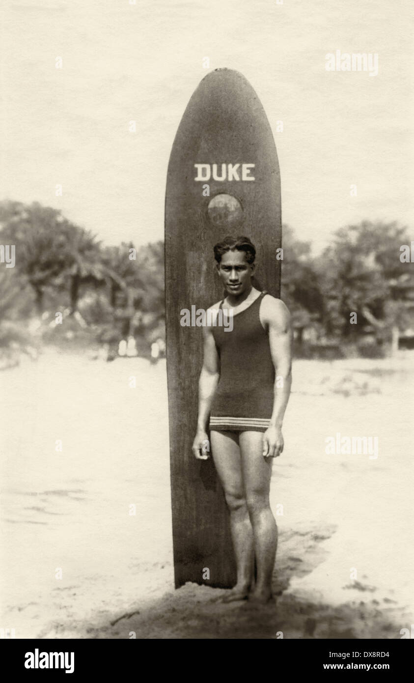 Duke Kahanamoku, der Vater des modernen Surfens, steht mit seinem hölzernen Surfbrett, c1912, auf einem Strand in Hawaii. Stockfoto